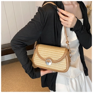 Détail du sac à bandoulière en paille tressée avec garniture en cuir et fermoir aimanté