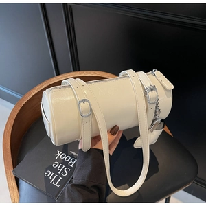 Detail of white oil wax leather cylindrical bag with silver heart charm and adjustable strap
