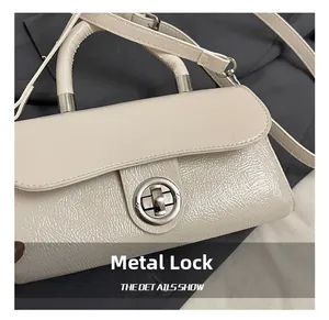 Detail shot of a beige PU leather handbag showing the silver metal twist lock closure