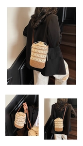 Close-up of beige woven bucket bag with contrast brown leather strap and drawstring liner