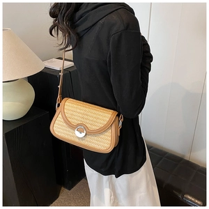 Détail du sac bandoulière en paille tressée avec bordure en cuir brun et fermoir