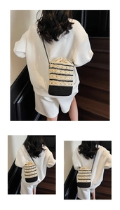 Detail view of woven straw bucket bag showing striped pattern and drawstring closure