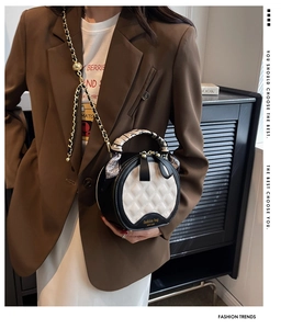 Détail du sac matelassé rond avec poignée en foulard de soie et bandoulière chaîne