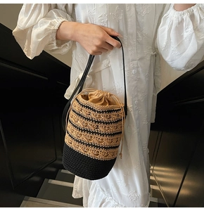 Detail of bohemian handwoven bucket bag with contrast stitching and drawstring closure