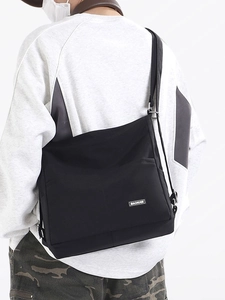 Minimalist black large capacity nylon tote bag shown in a stylish crossbody carry position
