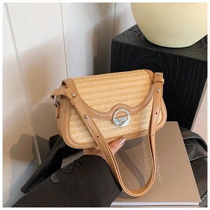 Vue détaillée du sac bandoulière en paille tissée avec finitions en cuir marron