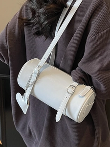 White cylinder crossbody bag in oil wax leather with heart charm and chain detail