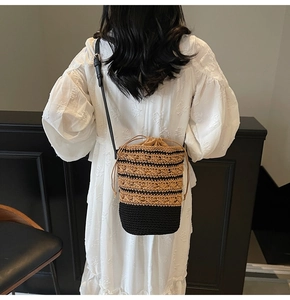Detail of bohemian bucket bag with woven striped texture and leather crossbody strap