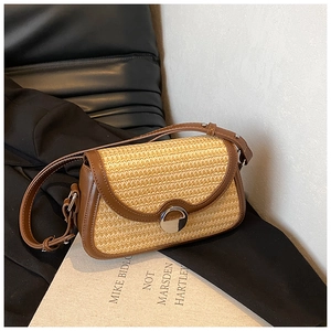 Détail de la texture en paille et de la bordure en cuir marron du sac bandoulière