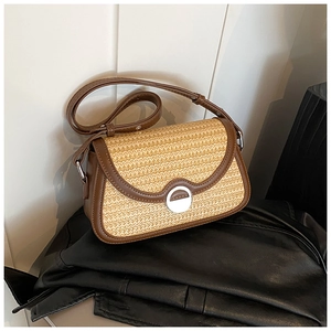Détail du tissage en paille et de la bordure en cuir marron du sac à bandoulière