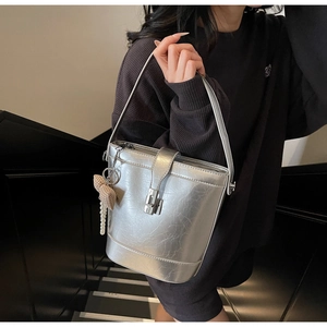 Dettaglio della borsa a secchiello argento metallizzato con trama vintage e perle