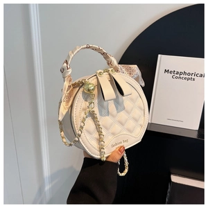 Detail of cream quilted round handbag with silk scarf handle and gold chain strap