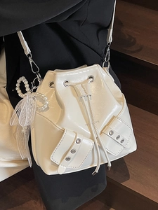 Sac seau blanc en cuir plissé avec breloque perle et œillets argentés sur les poches