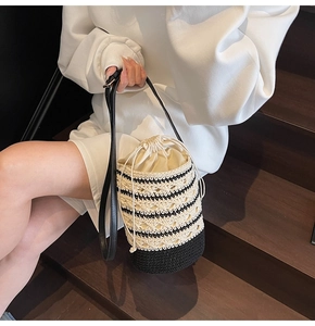 Detail of bohemian knit bucket bag with striped pattern and faux leather shoulder strap