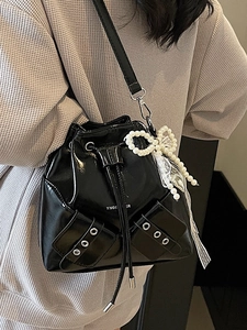 Sac seau noir brillant avec cordon de serrage, charme en perles et poches à œillets