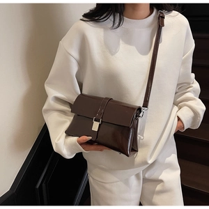 Close-up of vintage brown oil wax leather bag with silver metal clasp and smooth finish