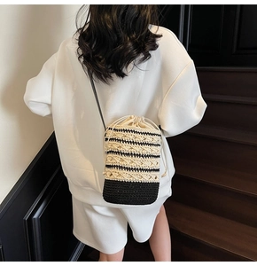 Detail of bohemian black and white woven bucket bag showing the texture and strap