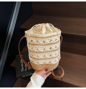 Detail of bohemian knit bucket bag featuring wavy crochet texture and leather shoulder strap