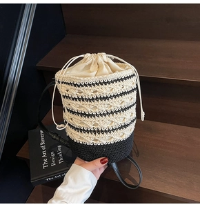 Detail of bohemian bucket bag featuring black and white woven mesh and drawstring closure