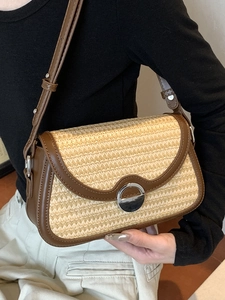 Sac à bandoulière en paille avec bordure en cuir marron et fermoir argenté élégant