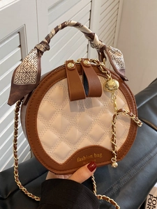 Elegant quilted round crossbody bag with contrast trim and scarf wrapped handles
