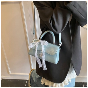 Detail of mint blue PU crossbody bag with white lace bow and elegant pearl handle