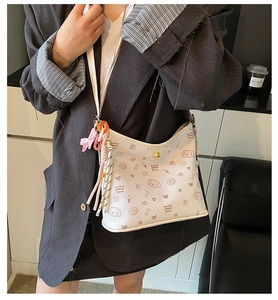 Detalle de bolso blanco con lindos estampados de dibujos animados y cierre dorado