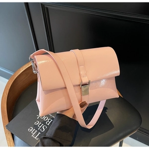 Close-up of pink glossy underarm bag with sleek silver rectangular metal buckle