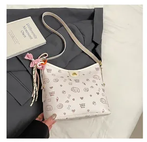 Primer plano de bolso tote blanco con estampados de cachorros y colgantes decorativos