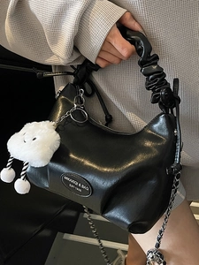 Elegant black glossy pleated handbag with metal chain strap and white fluffy cloud charm