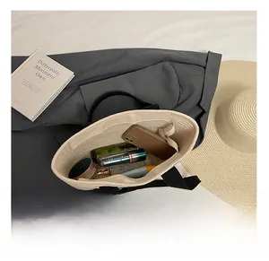 Interior espacioso del bolso de paja con teléfono y varios artículos cosméticos