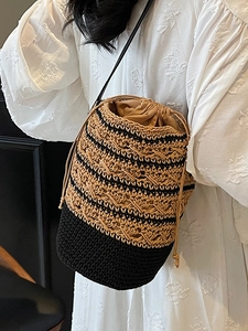 Bohemian knit bucket bag with brown straw pattern and black drawstring strap