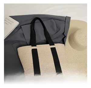 Primer plano del bolso de paja beige con correas negras en contraste para el verano
