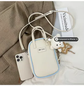 Comparaison de taille du sac de téléphone texture litchi avec iPhone 12 sur tissu