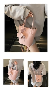 Borsa a secchiello rosa con trama litchi portata a mano e a tracolla con ciondolo
