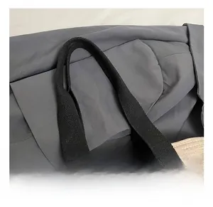 Detalle del asa de algodón y la textura tejida beige del bolso tipo cesta de paja trenzada