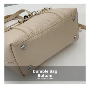 Detail of lychee pattern leather bag bottom with silver rivets and neat stitching