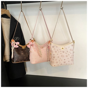 Detalle de tres bolsos hobo en marrón, rosa y beige con bonitos estampados de perros