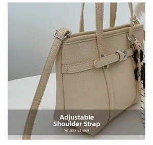 Detail of adjustable shoulder strap and litchi texture on beige bucket bag