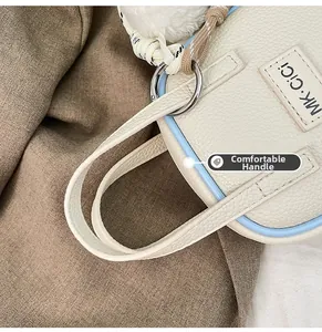 Détail du sac à main en cuir grainé avec bordure bleue contrastée et anses robustes
