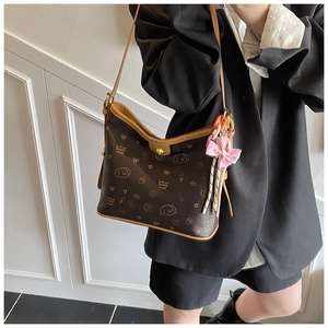 Detalle del bolso de hombro estampado con dibujos animados y colgante de lazo rosa