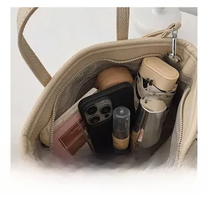 Detailed interior of beige lychee texture bucket bag showing large storage capacity