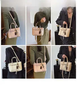 Detail of pink and beige bucket bag featuring litchi texture and cute charms