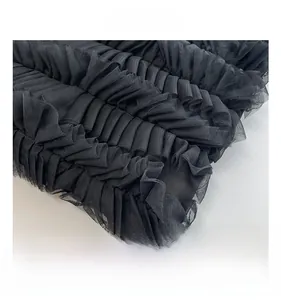 Gros plan détaillé des volants en maille noire et du tissu plissé du sac fourre-tout
