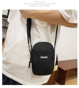 Mini black canvas crossbody phone bag featuring a mesh pocket and adjustable strap