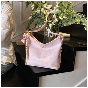 Detalle del bolso tote rosa claro estampado con perritos y colgantes de borlas