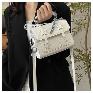 Detail of off-white star crossbody bag with checkered ribbon and lace handle decoration