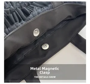 Détail de la boucle magnétique interne d'un sac cabas en maille noire multicouche