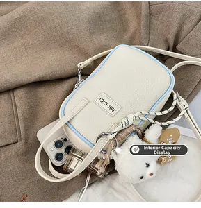 Capacité interne du sac bandoulière en cuir grainé avec téléphone, rouge à lèvres et ours