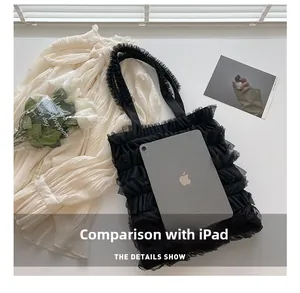 Vue détaillée du sac cabas en tulle à volants avec un iPad pour comparer la taille